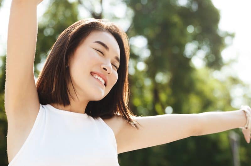 - close up asian woman stretching hands up smiling walking park looking carefree happy - ภาพที่ 17