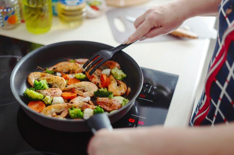 - woman staying home kitchen cooking shrimps with vegetables pan home cooking healthy cooking concept - ภาพที่ 5