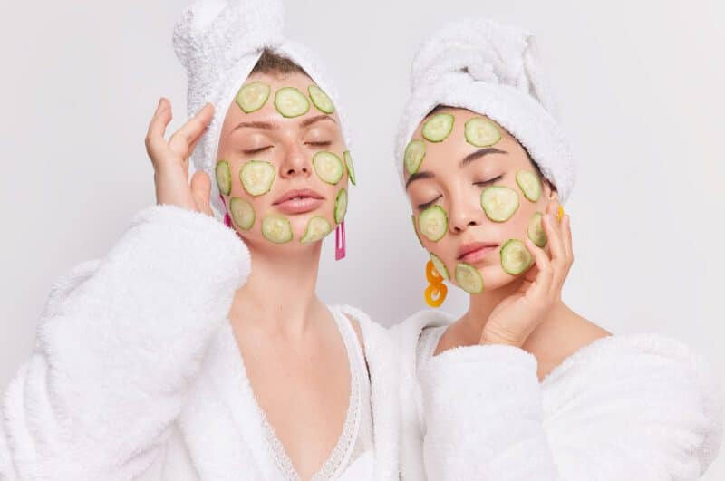 - portrait two mixed race women stand with closed eyes apply cucumber slices face moisturize enjoy softness skin - ภาพที่ 7