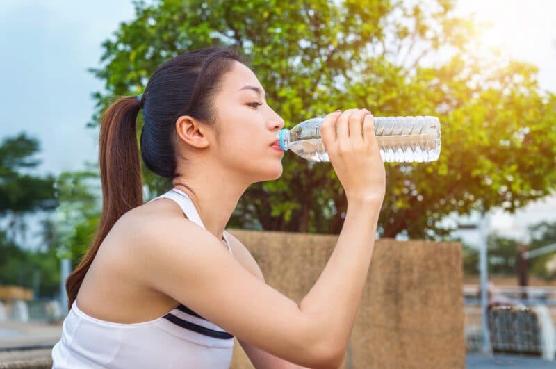 - sporty young woman drinking water after jogging - ภาพที่ 3