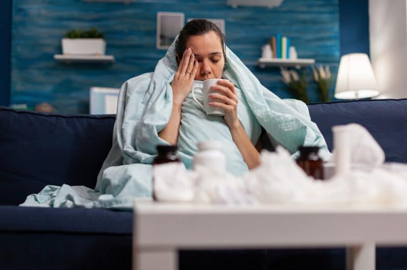 - sick woman sitting home blanket with hot tea - ภาพที่ 3