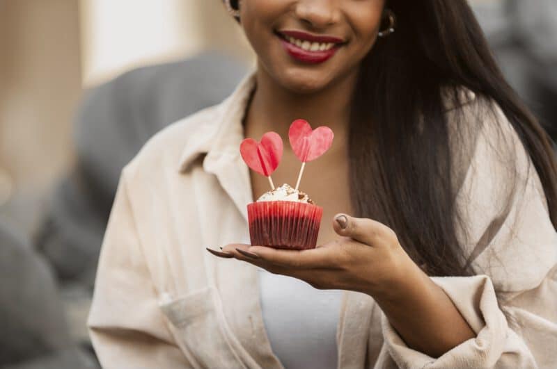 แคปชั่นอ่อยน่ารัก ๆ - smiley woman holding valentine s day cupcake - ภาพที่ 4