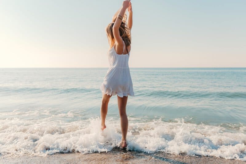 แต่งตัวไปทะเล - young attractive happy woman dancing turning around by sea beach sunny summer fashion style white dress vacation - ภาพที่ 3