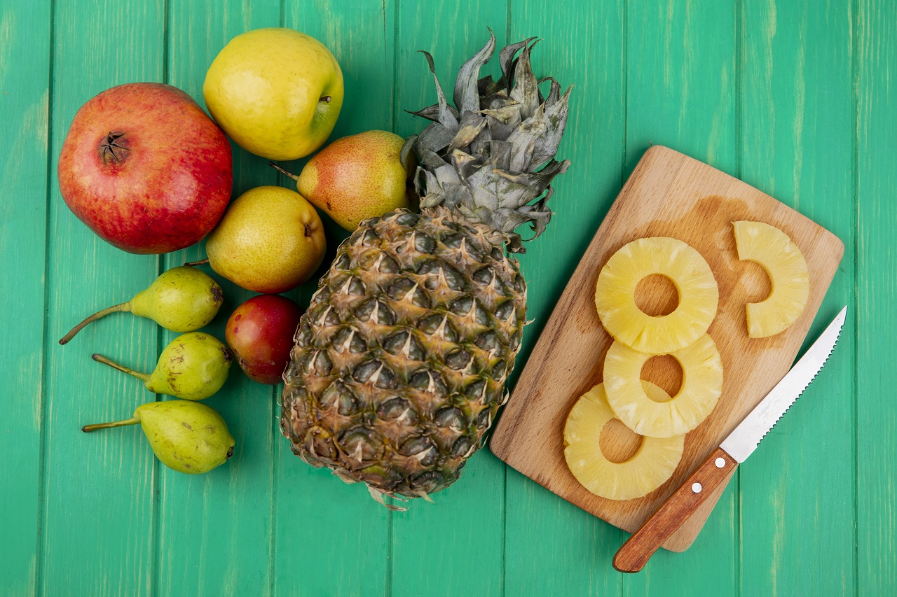 วิธีคลายร้อน - top view pineapple slices with knife cutting board pineapple pomegranate peach plum green surface - ภาพที่ 7
