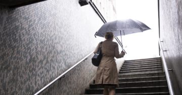 woman going out city while it rains