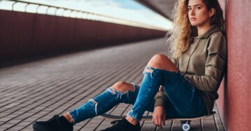 กางเกงยีนส์ขาด - portrait young woman dressed hoodie ripped jeans leaning wall while sitting skateboard bridge footway Large - ภาพที่ 1